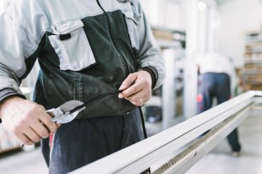 Alüminyum ve Pvc pencere ve kapı üretimi için fabrika. Pvc kapı ve pencereleri monte eden el işçisi. Seçici odaklama. 