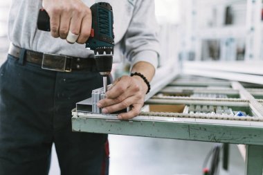 Alüminyum ve Pvc pencere ve kapı üretimi için fabrika. Pvc kapı ve pencereleri monte eden el işçisi. Seçici odaklama. 