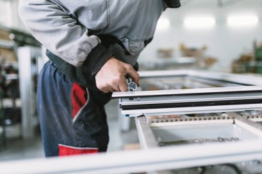 Alüminyum ve Pvc pencere ve kapı üretimi için fabrika. Pvc kapı ve pencereleri monte eden el işçisi. Seçici odaklama. 