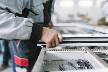 Alüminyum ve Pvc pencere ve kapı üretimi için fabrika. Pvc kapı ve pencereleri monte eden el işçisi. Seçici odaklama. 