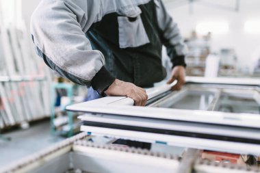 Alüminyum ve Pvc pencere ve kapı üretimi için fabrika. Pvc kapı ve pencereleri monte eden el işçisi. Seçici odaklama. 