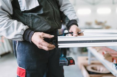 Alüminyum ve Pvc pencere ve kapı üretimi için fabrika. Pvc kapı ve pencereleri monte eden el işçisi. Seçici odaklama. 