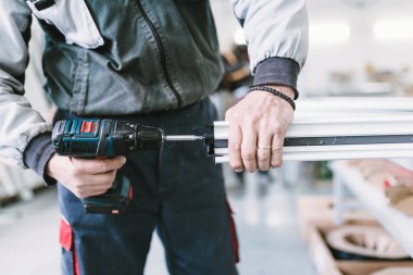 Alüminyum ve Pvc pencere ve kapı üretimi için fabrika. Pvc kapı ve pencereleri monte eden el işçisi. Seçici odaklama. 