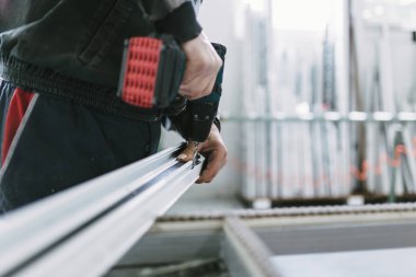 Alüminyum ve Pvc pencere ve kapı üretimi için fabrika. Pvc kapı ve pencereleri monte eden el işçisi. Seçici odaklama. 