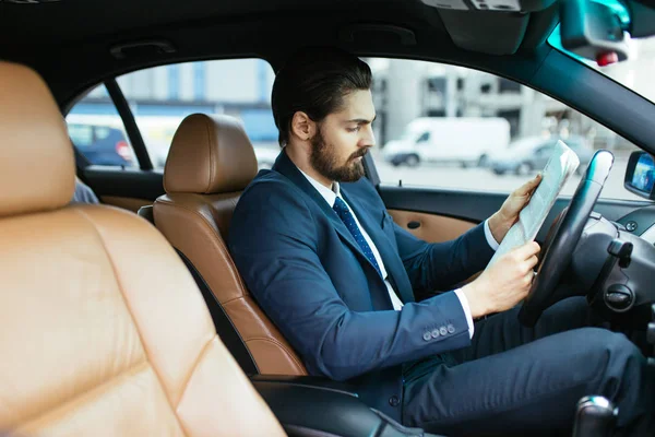 Επιχειρηματίας Διαβάζει Εφημερίδα Στο Αυτοκίνητό Του Περιμένοντας Τον Βοηθό Του — Φωτογραφία Αρχείου