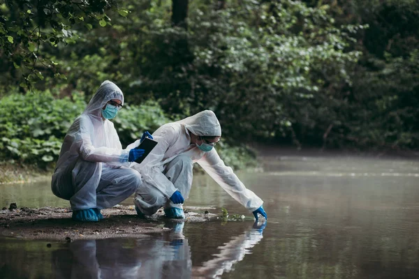 Two Scientists Protective Suits Taking Water Samples River — Stock Photo, Image