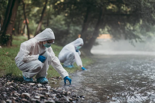 Два Учёных Защитных Костюмах Берут Образцы Воды Реки — стоковое фото