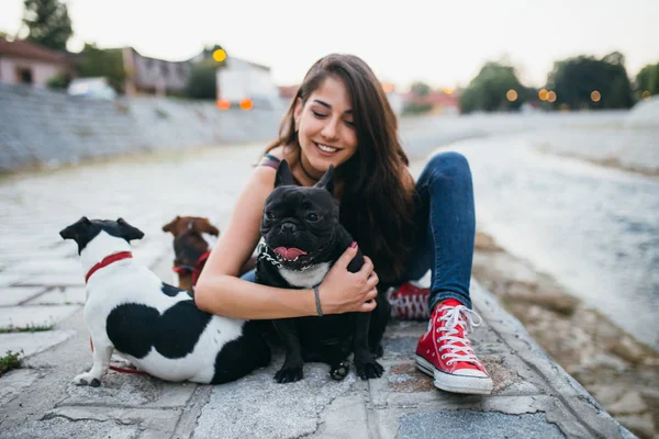 都市の川の隣で屋外で楽しむ犬と犬の歩行者 — ストック写真