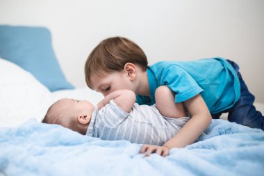 Küçük çocuk küçük kardeşi ile birlikte oynuyor. 