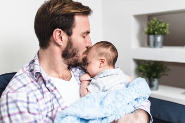 Yakışıklı baba onun sevimli küçük bebek erkek bebek tutan. 