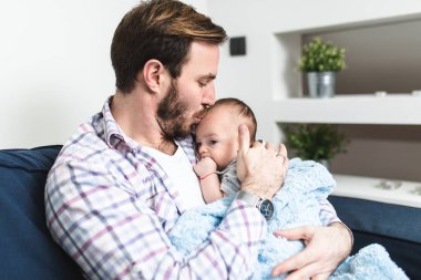 Yakışıklı baba onun sevimli küçük bebek erkek bebek tutan. 