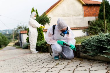 İş yerinde yok ediciler püskürtücü ile pestisit püskürtme giymek.