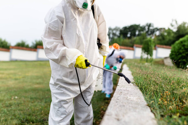 Дезинсекторы на открытом воздухе при работе изнашивают пестициды с распылителем
.