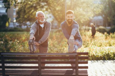 Mutlu iyi görünümlü baba ve oğlu parkta birlikte egzersiz.