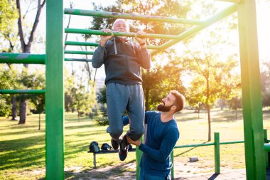 Mutlu iyi görünümlü baba ve oğlu parkta birlikte egzersiz.
