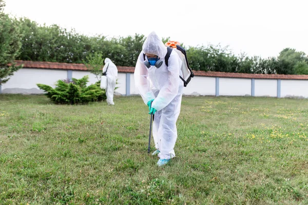 作業中の屋外の駆除機は 噴霧剤で農薬を吹き付けます — ストック写真