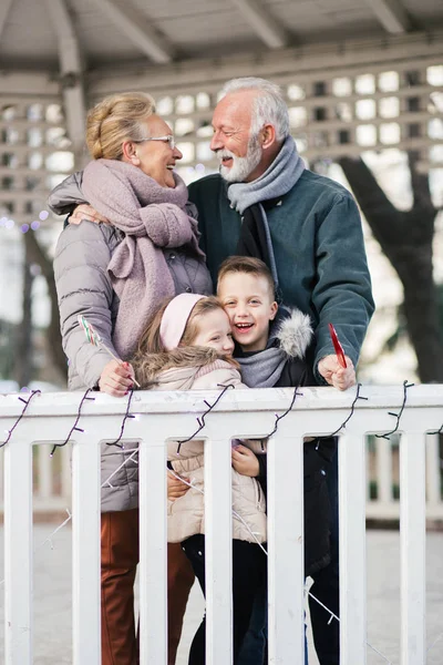 Grandparents having fun with their grandchildren in city park.