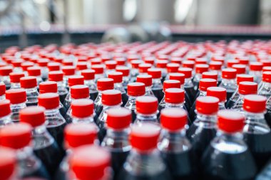 Şişeleme fabrikası, şişelere meyve suyu işlemek ve şişelemek için kullanılıyor. Seçici odak. 