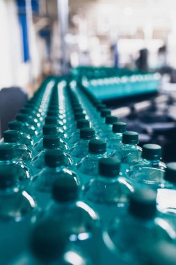 Şişeleme tesisi - Küçük şişeler halinde saf kaynak suyu işleme ve şişeleme için su şişeleme hattı. Seçici odaklama.