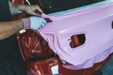 Araba ambalaj uzmanı arabaya vinil folyo ya da film koyuyor. Seçici odak. 