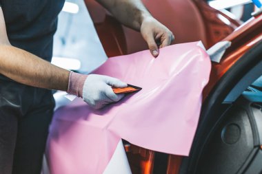 Araba ambalaj uzmanı arabaya vinil folyo ya da film koyuyor. Seçici odak. 