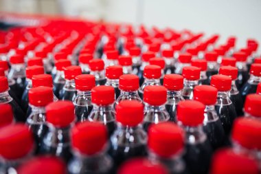 Şişeleme fabrikası, şişelere meyve suyu işlemek ve şişelemek için kullanılıyor. Seçici odak. 