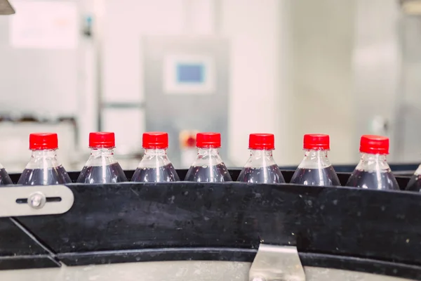 Bottling factory - Black juice bottling line for processing and bottling juice into bottles. Selective focus.