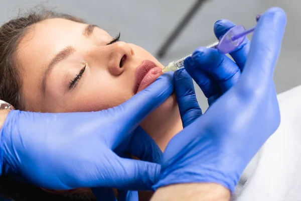 Medical procedure on woman\'s lips with hyaluronic acid.