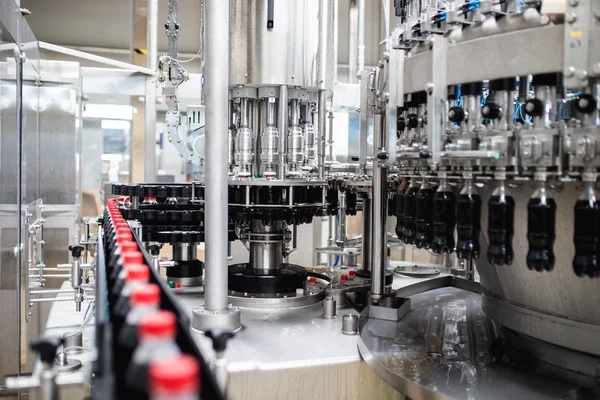 Bottling factory - Black juice bottling line for processing and bottling juice into bottles. Selective focus.