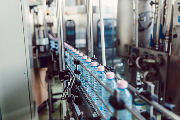 Bottling plant - Water bottling line for processing and bottling carbonated water into bottles. Selective focus. 