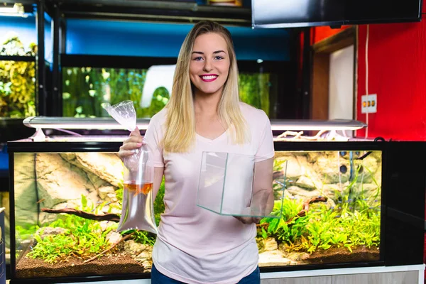 Beautiful young woman buying fishes in a fish shop.