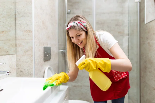 Young and happy woman cleaning house bathroom