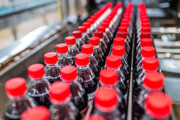 Bottling factory - Black juice bottling line for processing and bottling juice into bottles. Selective focus.