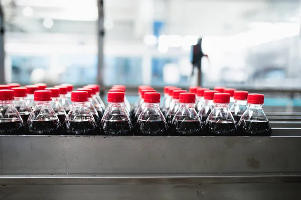 Bottling factory - Black juice bottling line for processing and bottling juice into bottles. Selective focus.