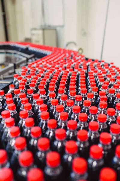 Bottling factory - Black juice bottling line for processing and bottling juice into bottles. Selective focus.