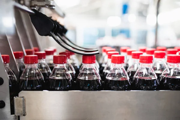 Bottling factory - Black juice bottling line for processing and bottling juice into bottles. Selective focus.