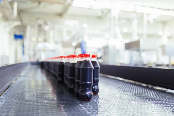 Bottling factory - Black juice bottling line for processing and bottling juice into bottles. Selective focus.