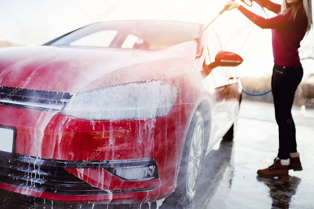 Car washing. Cleaning car using high pressure water. Selective focus.