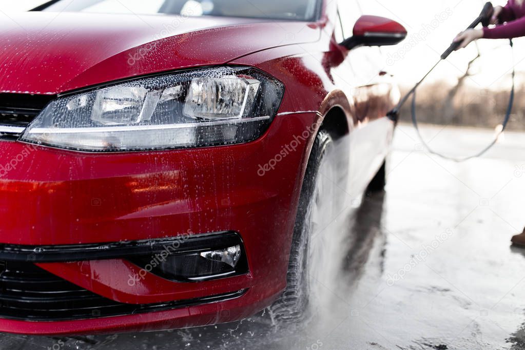 Car washing. Cleaning car using high pressure water. Selective focus. 