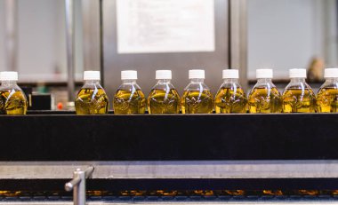 Bottling factory - Apple juice bottling line for processing and bottling juice into bottles. Selective focus.  clipart