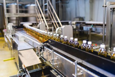 Bottling factory - Apple juice bottling line for processing and bottling juice into bottles. Selective focus.  clipart