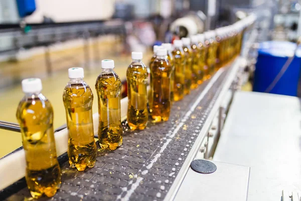 瓶詰め工場 ボトルにジュースを処理し 瓶詰めするためのアップルジュース瓶詰めライン 選択的焦点 — ストック写真