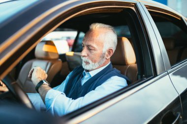 Limuzininde oturan kıdemli iş adamı. İş konsepti. Arka ışık.