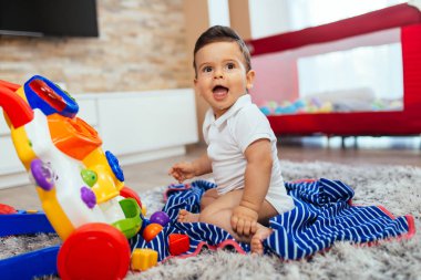 Oturma odasında oyuncaklarla oynayan sevimli küçük çocuk..