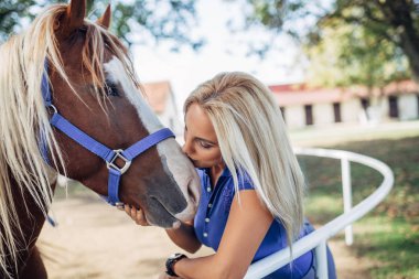 Çekici sarışın kadın güzel midilli atıyla eğleniyor..