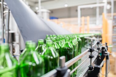 Şişeleme tesisi - Küçük şişeler halinde saf kaynak suyu işleme ve şişeleme için su şişeleme hattı. Seçici odaklama.