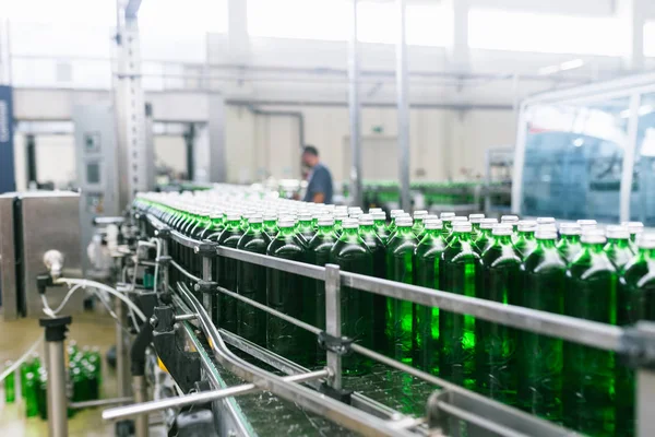 处理纯泉水并将其装瓶成绿色玻璃瓶的装瓶生产线 有选择的重点 — 图库照片