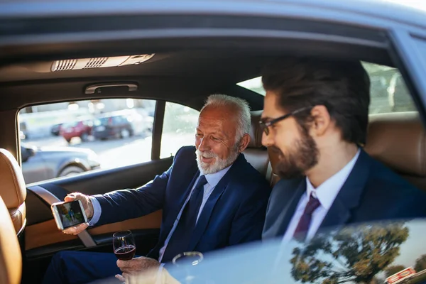 Senior Geschäftsmann Und Sein Assistent Sitzen Der Limousine Und Sprechen — Stockfoto