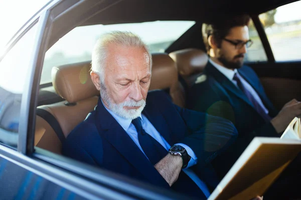 Senior Geschäftsmann Und Sein Assistent Sitzen Der Limousine Und Arbeiten — Stockfoto
