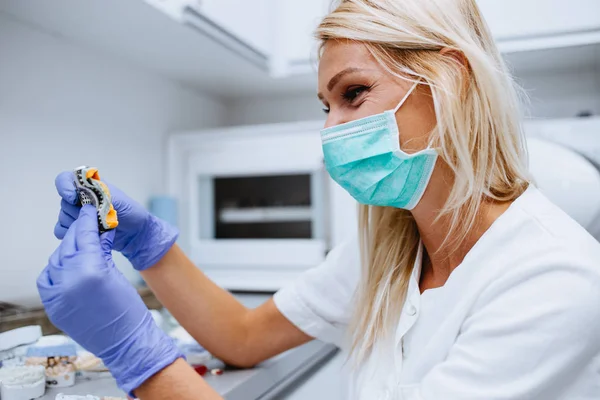 Dental technician making dentures. Dental prosthesis, prosthetics work.